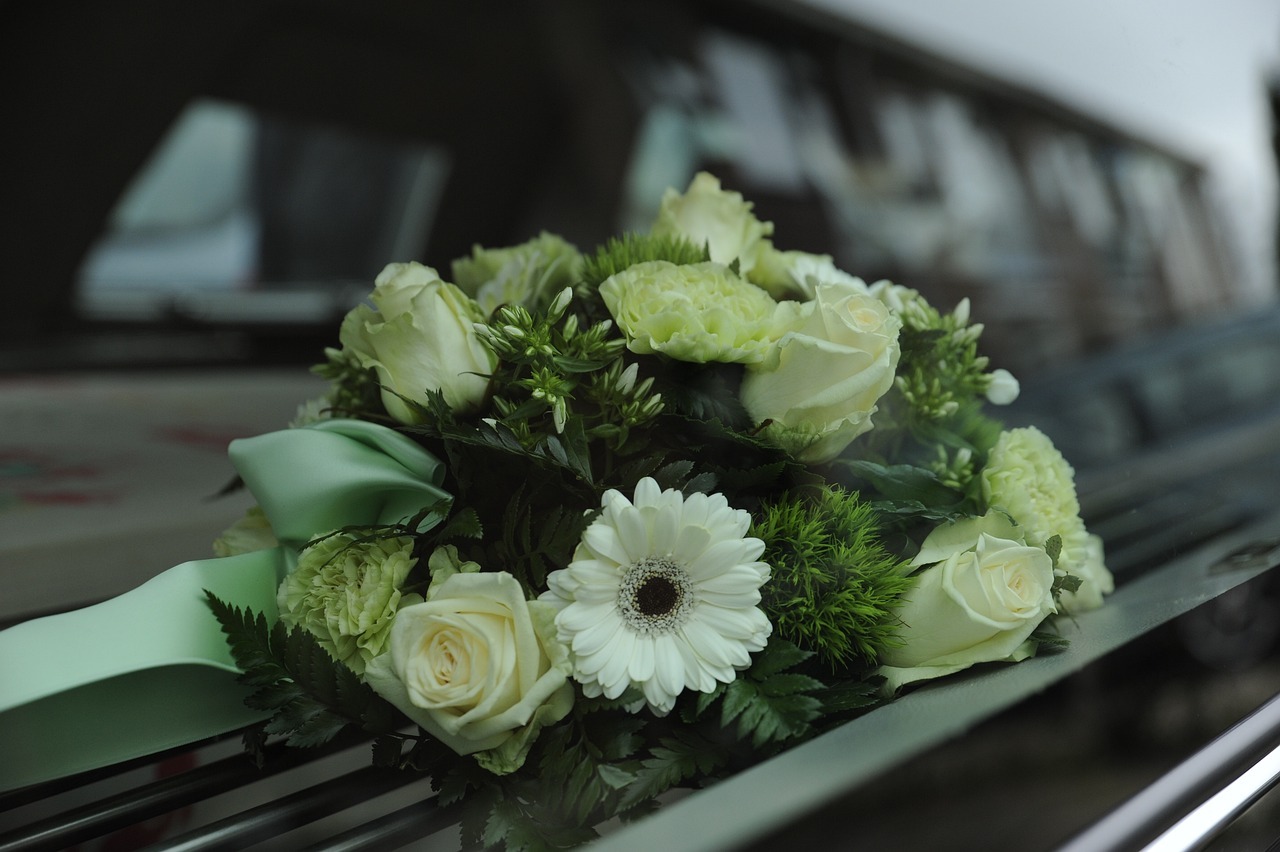 Begrafeniskist zwart met bloemen